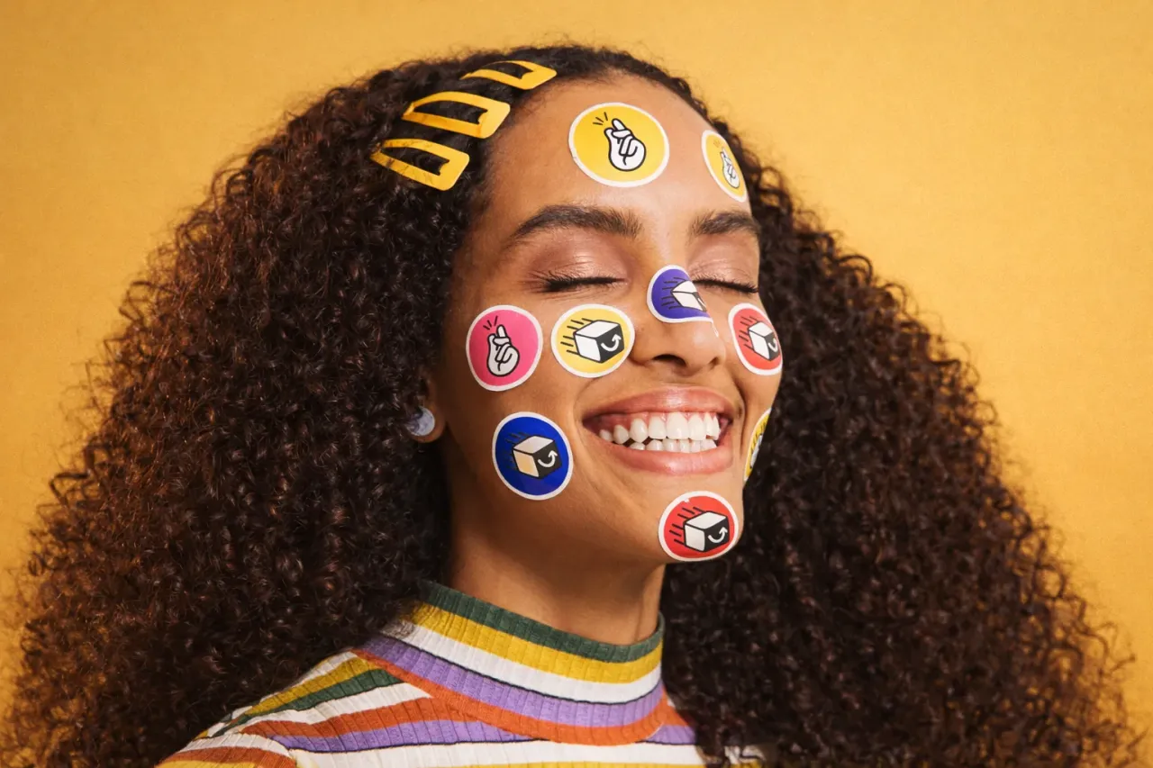 Retrato de uma mulher sorrindo com adesivos da marca Bestmile no rosto